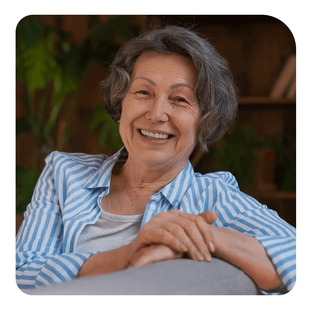Senhora sorrindo sentada no sofá